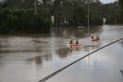 Police and SES in inflatables heading north along the Centenary Highway.