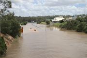 Police and SES in inflatables heading north along the Centenary Highway. Buildings on the right are DFO Jindalee.